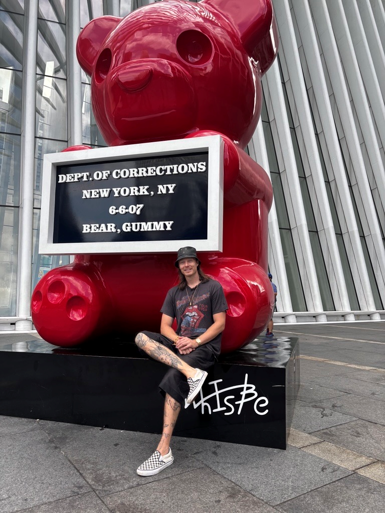 whisbe artist next to giant sculpture